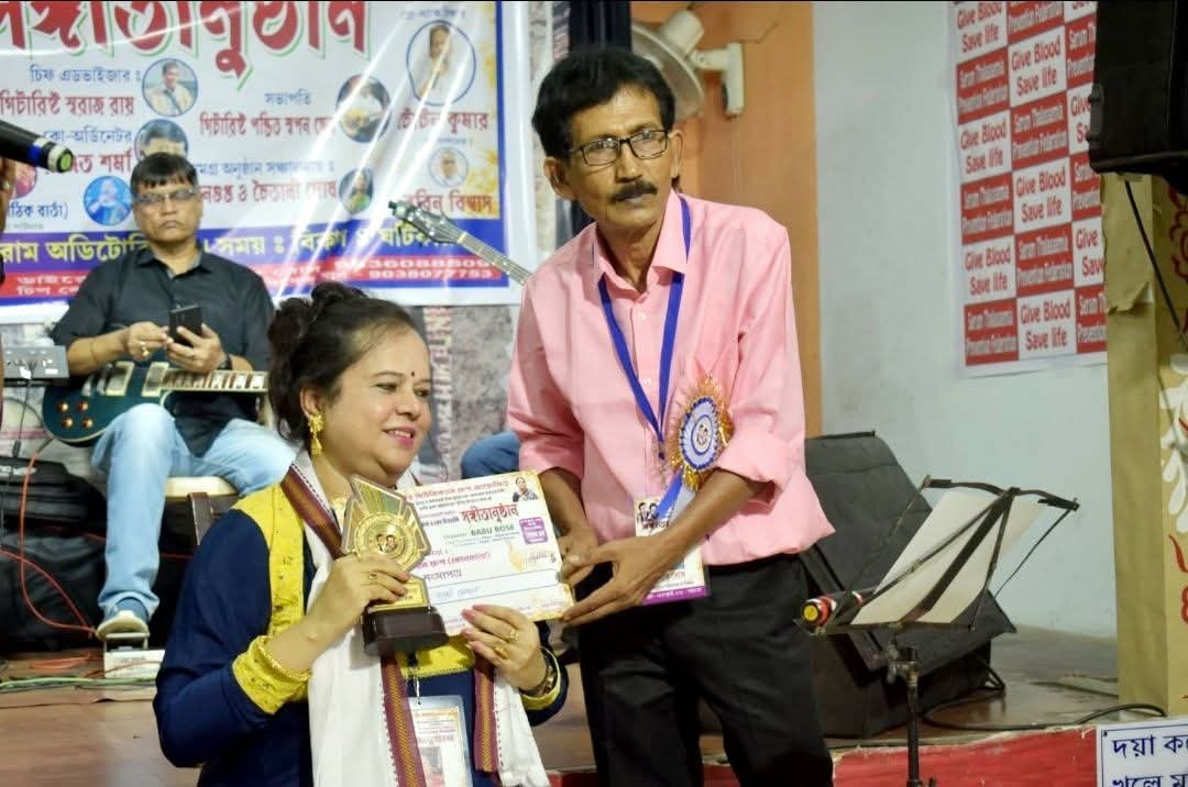 Banasri Ghoshal receiving a certificate on stage